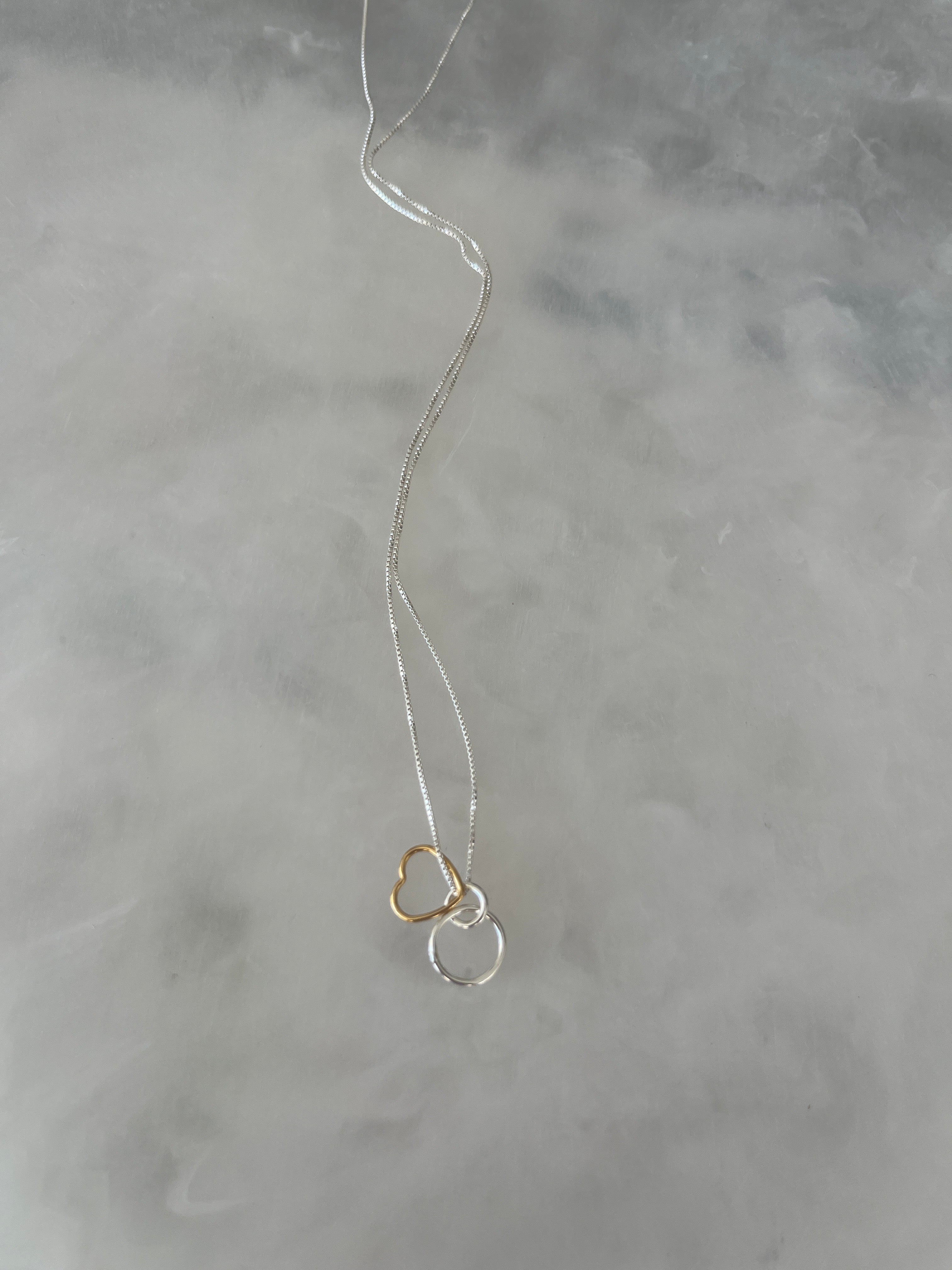 Solid silver necklace with silver circle link and gold heart