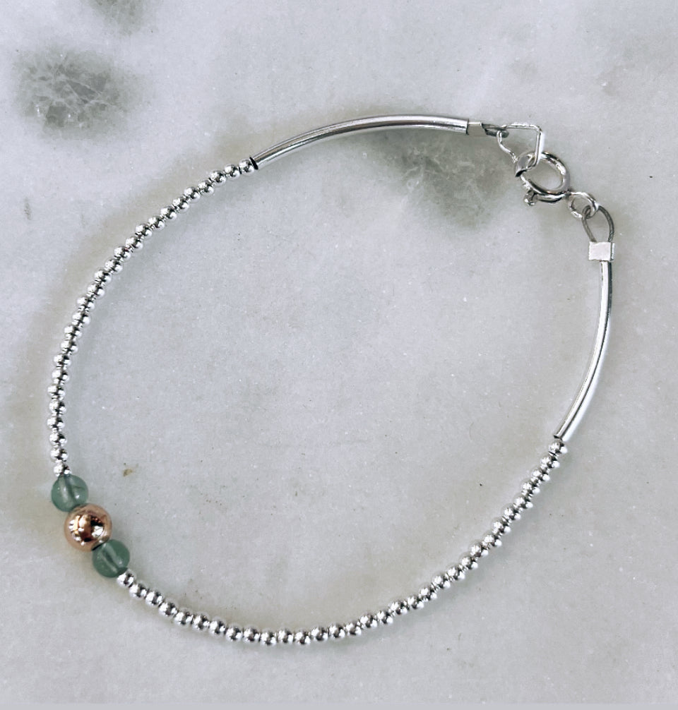 Solid silver bracelet with aqua apatite gemstones and gold ball